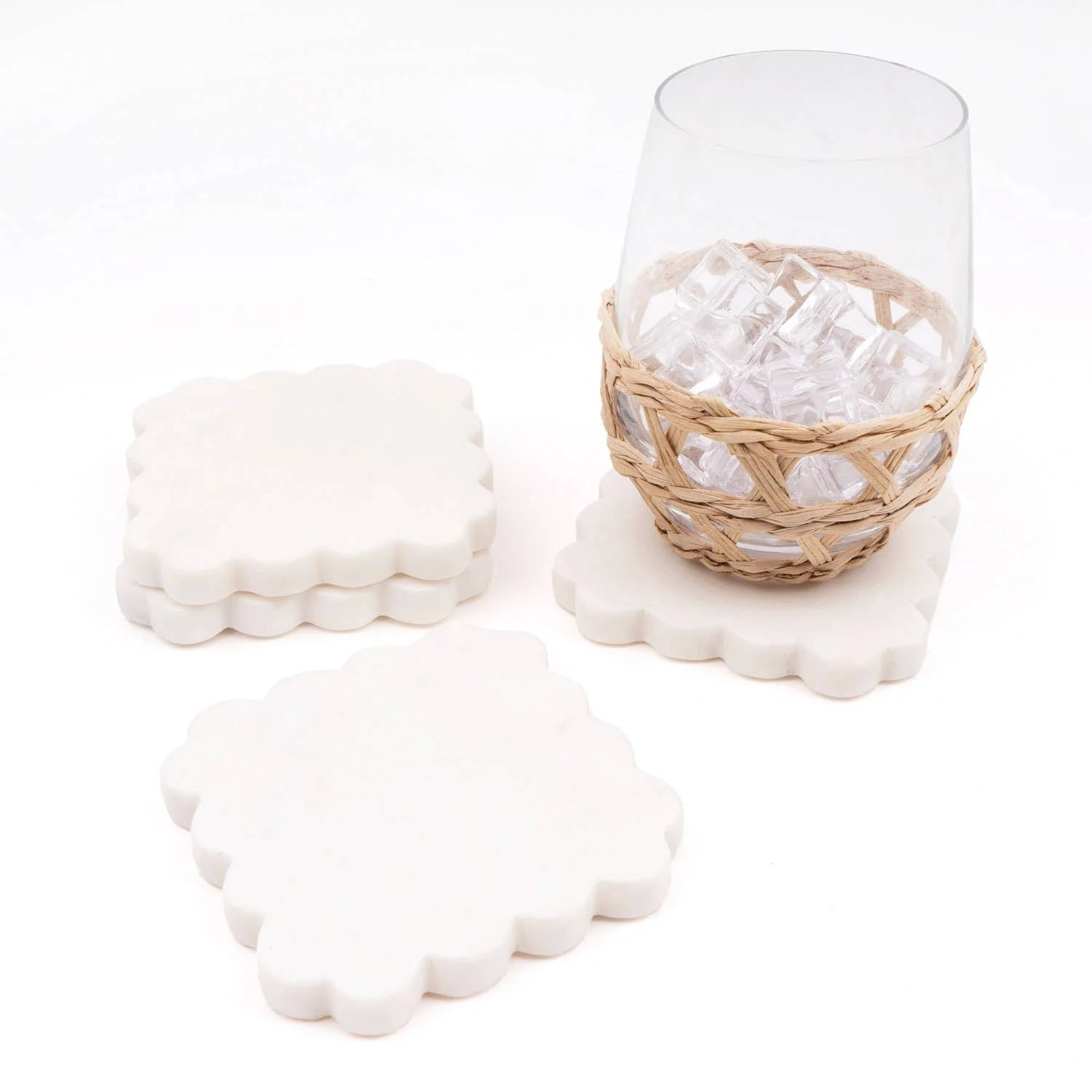 Set of four white marble scalloped coasters with natural veining for drinks, coffee tables, bar carts, and tabletop protection