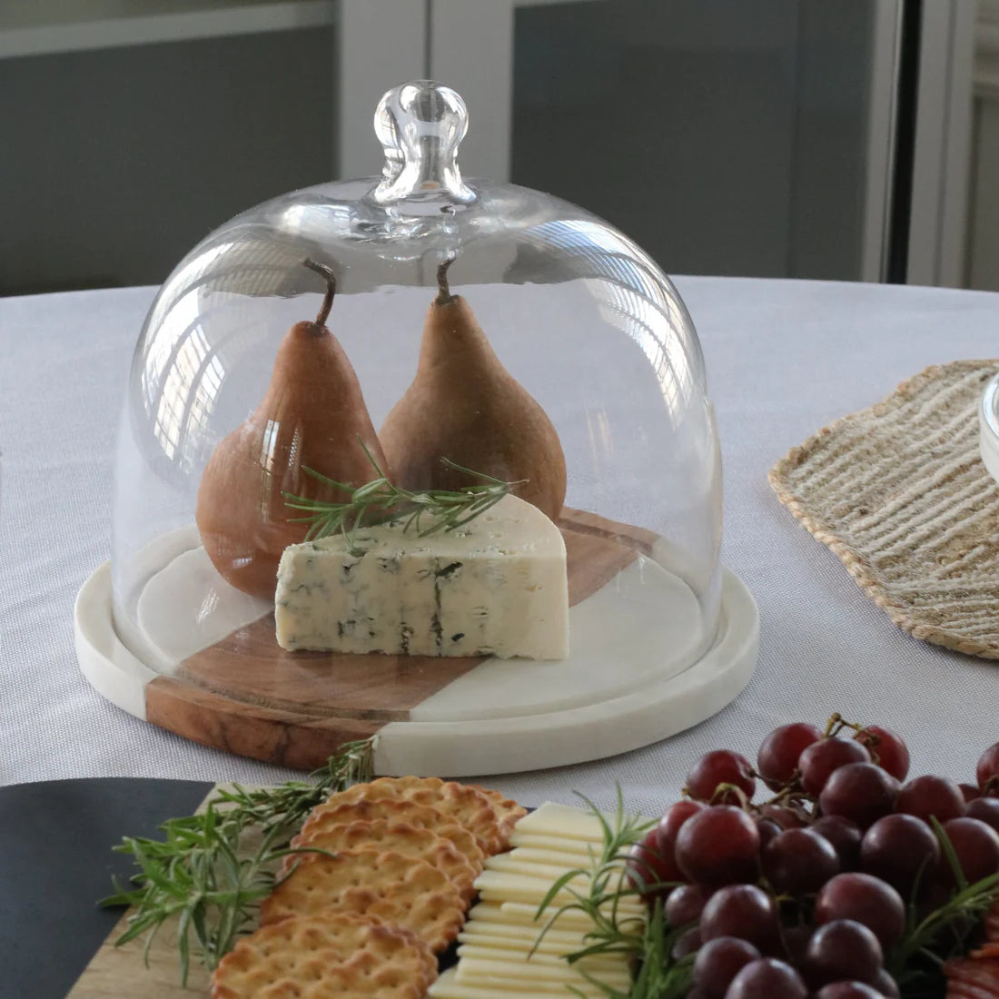 
White marble and natural wood glass cloche for displaying desserts, cheese, pastries, and kitchen treats


